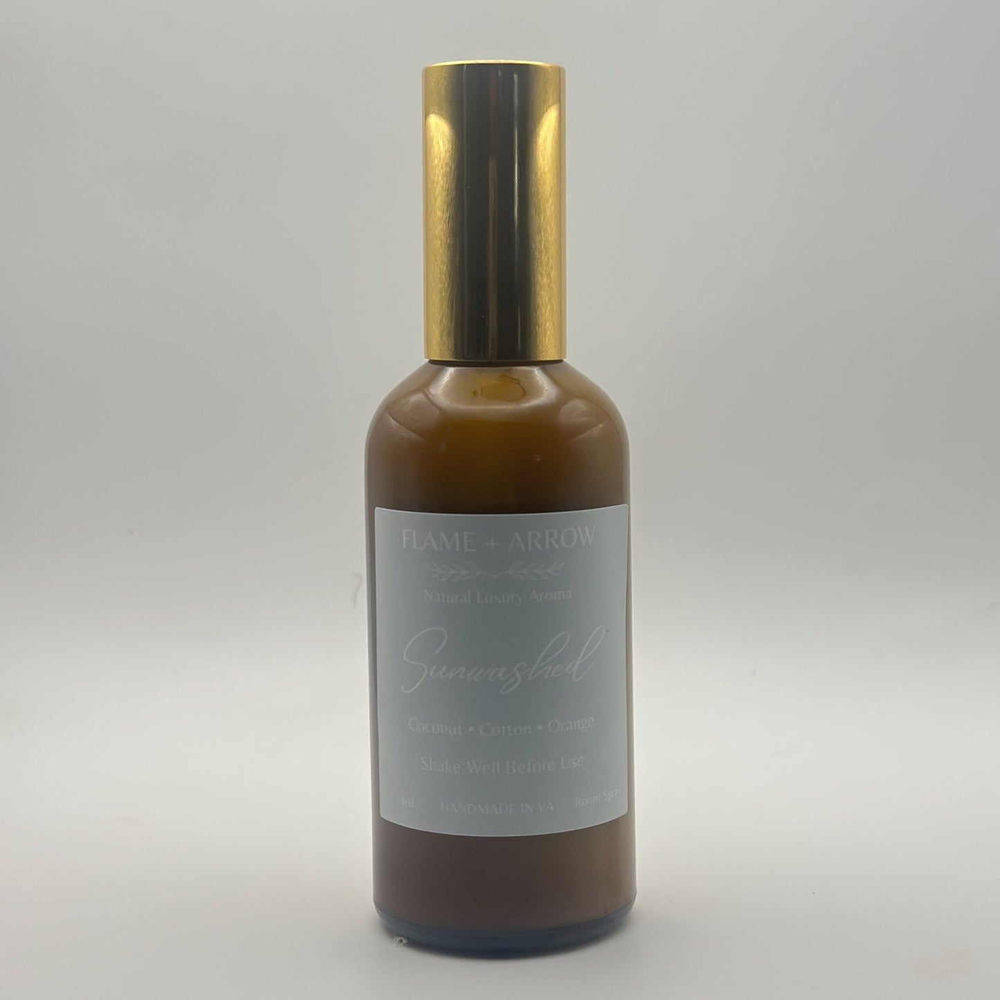 A cotton coconut orange scented room spray in an amber bottle with gold top