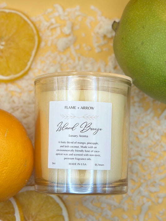 Island Breeze Candle with background of oranges, mango, and shredded coconut.