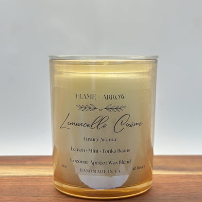 A clear glass candle jar with a label that reads 'Flame Arrow Limoncello Crème Luxury Aroma', with additional scent notes listed below.