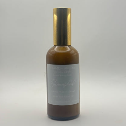 A cotton coconut orange scented room spray in an amber bottle with gold top